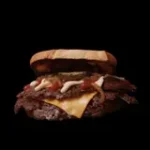 Brioche bun, double beef patty (2x 80 gr.), ketcup, mayonaise, caramelized onions, cheddar, lettuce and pickles